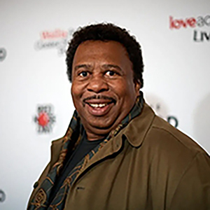 Leslie David Baker wearing a beige suit attending a movie premier